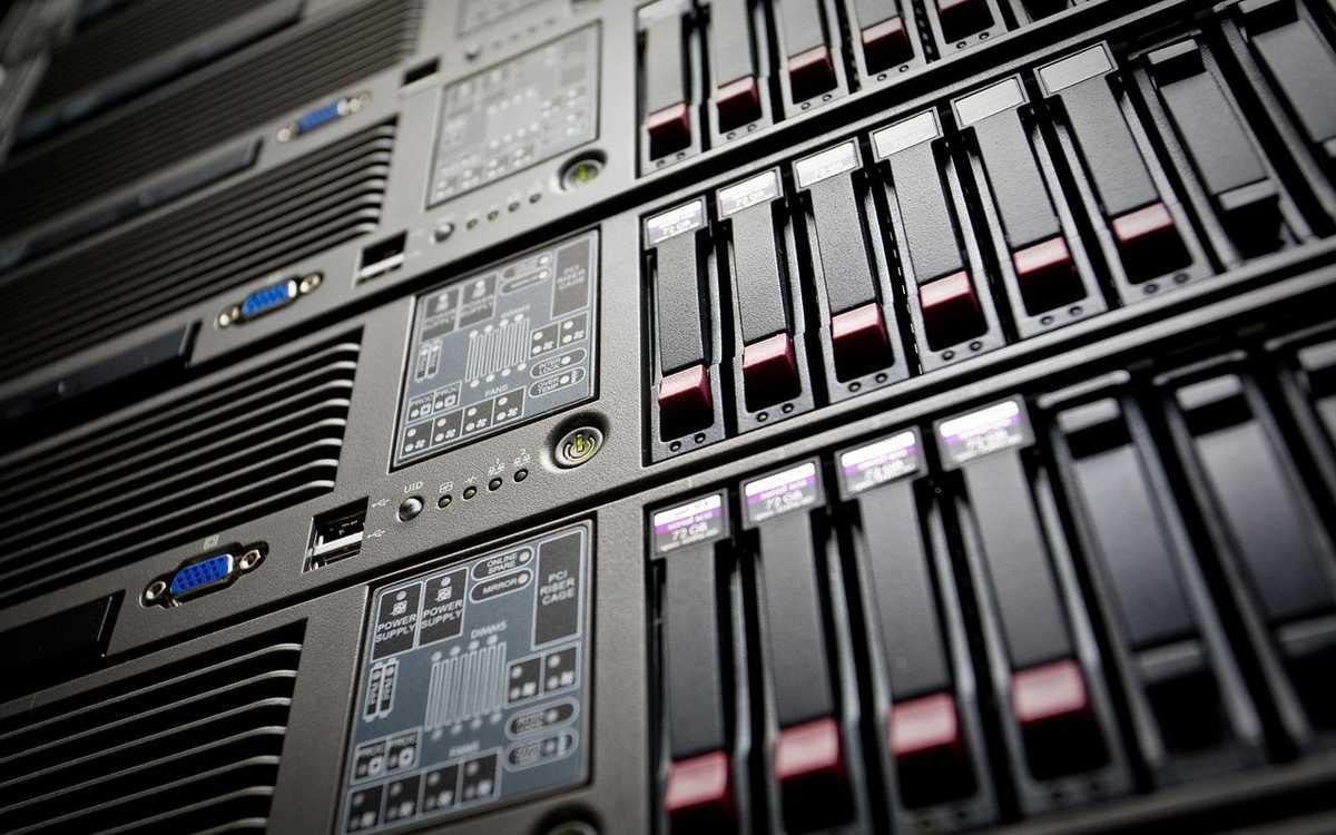 Baie de serveurs avec disques durs dans un datacenter, rangées de lecteurs de stockage